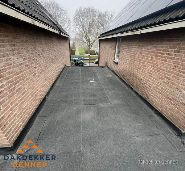 Plat dak met bitumen dakbedekking tussen bakstenen muren in Gennep Plat dak met bitumen dakbedekking tussen bakstenen muren in Gennep